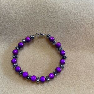 Handmade bracelet with purple and silver colored beads.